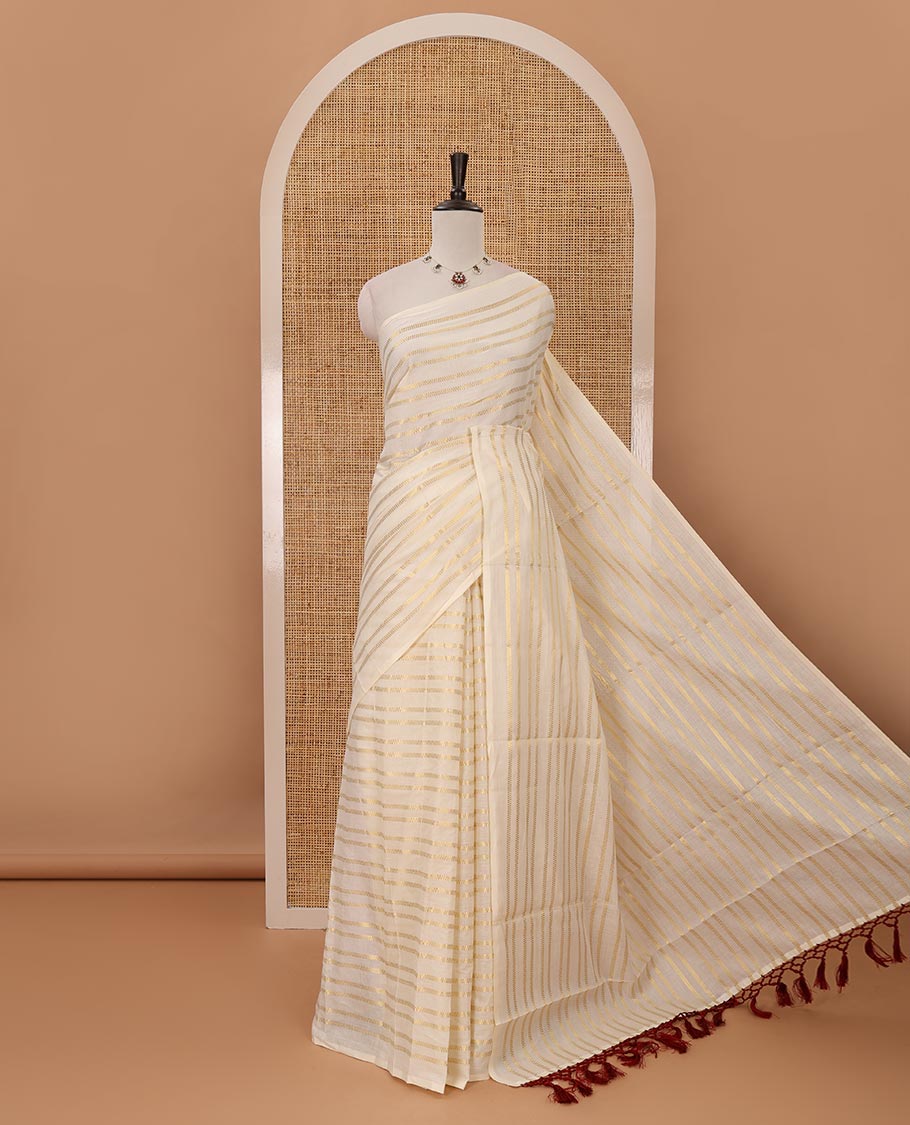 Borderless cream Veldhari-style striped Kerala cotton saree, zari design pallu with maroon tussels & zari design blouse