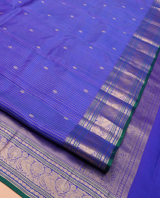 Blue Vasundhara Silk Saree, Subtly Sparkled with Zari Buttas and Micro-Checks on Its Body, Highlighted by a Zari Border of Rekku, Banaras, Muthu, Rudraksham, and Mayil Designs, Diagonally Striped Pallu, and Paired with a Contrast Blouse