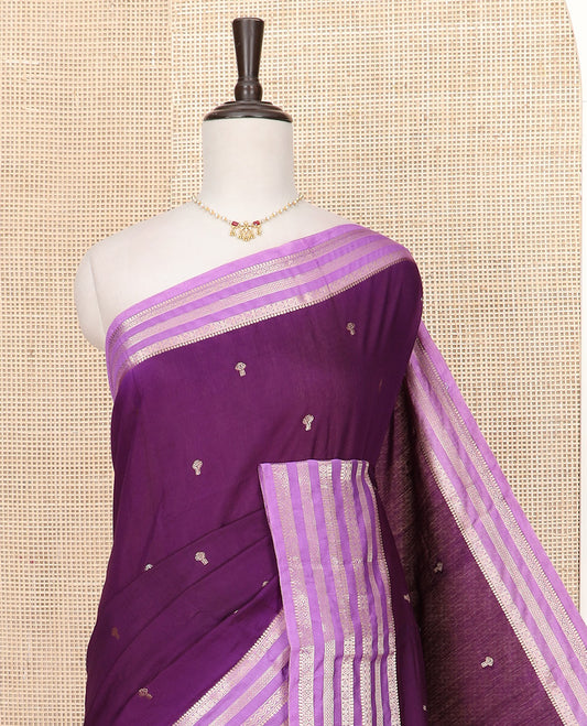 Purple Assam Silk Saree Adorned with Zari Buttas, complemented by Contrast Zari Border Featuring Traditional Zari Designs, a Gleaming Pallu of Zari Stripes, and Paired with a Contrast Blouse