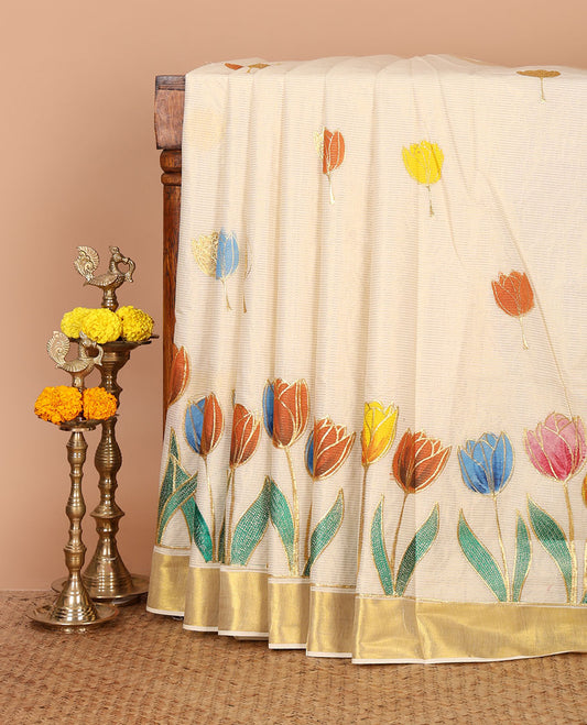 Cream Kerala cotton saree with zari stripes,hand-brush lotus motif painting & embroidery outlines, zari border & zari striped blouse