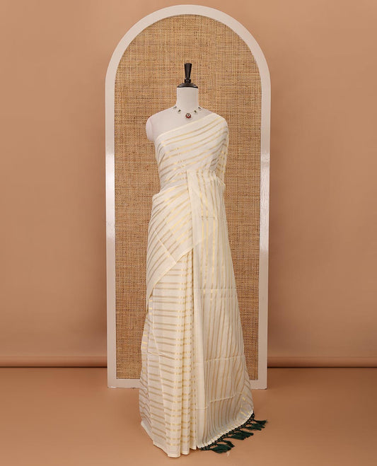 Borderless cream Veldhari-style striped Kerala cotton saree, zari design pallu with green tussels & zari design blouse