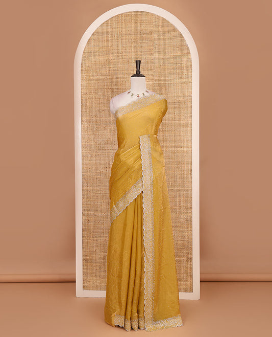 Mustard Swarovski crystal stone embedded fendy chiffon saree, scallop Swarovski stone embroidered border, and contrast plain blouse