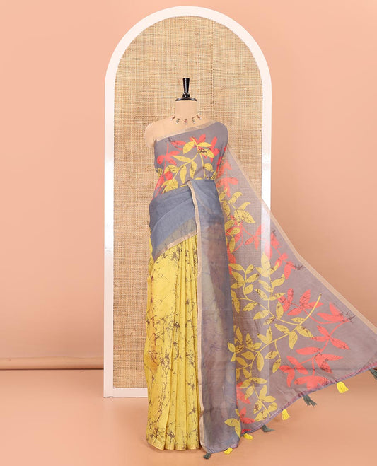 Yellow and grey batik print and leaf vine printed linen saree, zari piping border, printed pallu, and a contrast batik printed blouse