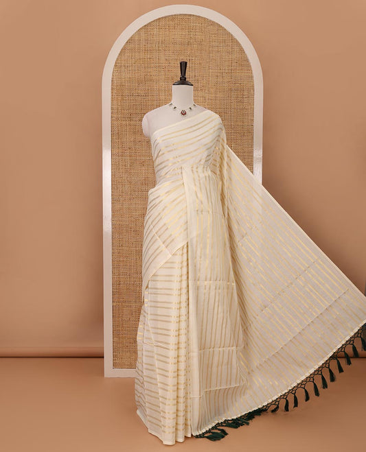 Borderless cream Veldhari-style striped Kerala cotton saree, zari design pallu with green tussels & zari design blouse