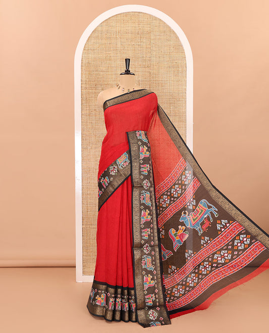 Red embossed moss chiffon saree, contrast zari and colorfully printed border and pallu of human figurines and Pichwai cows, and embossed blouse