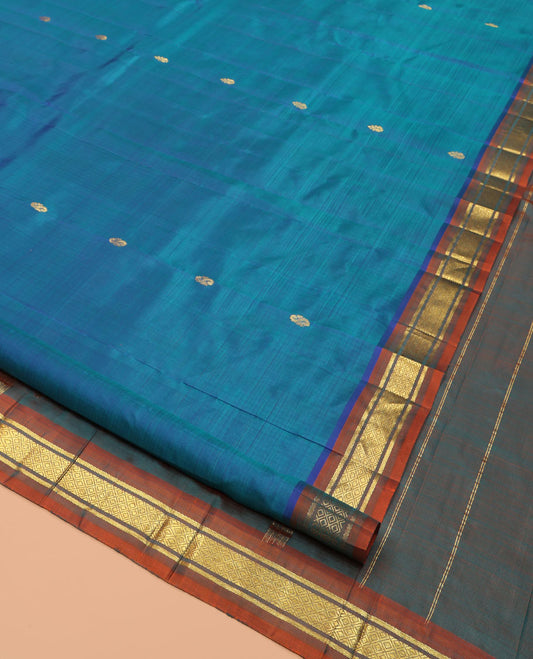 Blue Kanchipuram Silk Saree, Elevated with Zari Buttas, Complemented by a Contrast One-Sided Border of Banaras, and Mayil Kann Designs, Zari Woven Pallu, and a No Blouse