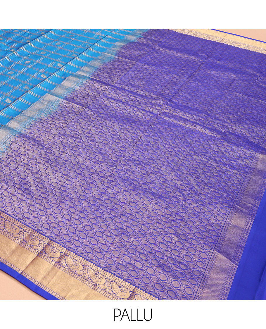Blue Vasundhara Lite-Silk Mix Saree, Spotlighted with Yaanai, and Chakram Butta Enclosed Checks, Complemented by a Contrast Border of Thilakam, Poun, and Mayil Designs, Pallu Highlighted by Geometric Designs, and Paired with a Contrast Blouse