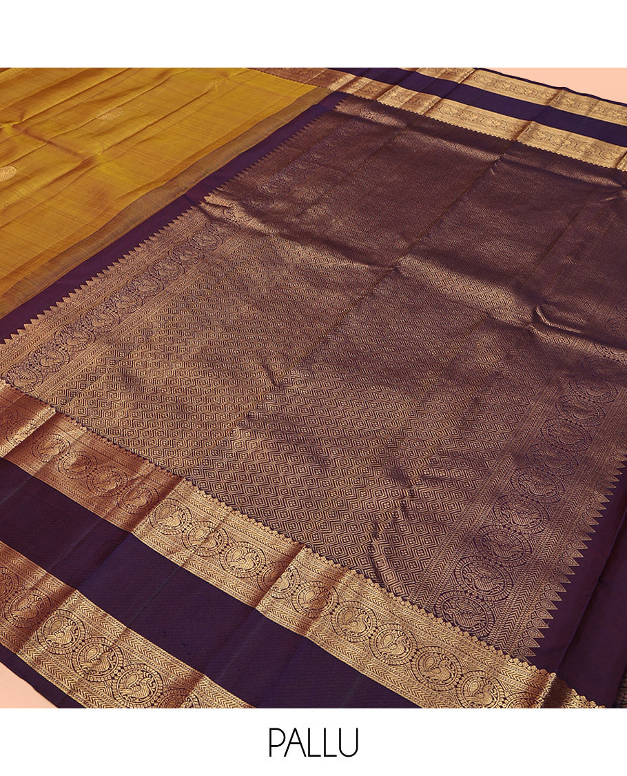 Mustard Kanchipuram Silk Saree, Embellished with Round Buttas All Over Its Body, Complemented by a Contrast Rettai Pettu Border of Thilakam Mokku, Muthu, Kathir, and Round Mayil Designs, Grand Jaal Pallu, and Paired with a Contrast Blouse