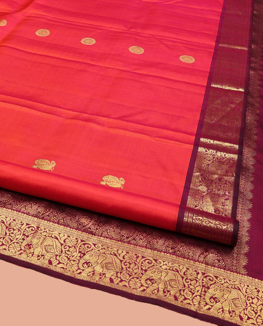 Orange Kanchipuram Silk Saree, Mesmerized with Mayil and Chakram Buttas All Over Its Body, Complemented by Contrast Border of Thilakam, Cross Kamalam, and Yaanai Designs, Pallu Steeped with Rettai Mayil Designs, and Paired with a Contrast Blouse