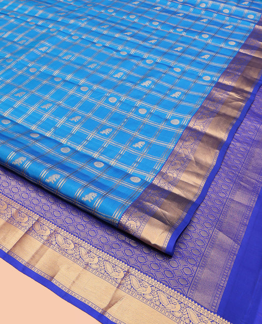 Blue Vasundhara Lite-Silk Mix Saree, Spotlighted with Yaanai, and Chakram Butta Enclosed Checks, Complemented by a Contrast Border of Thilakam, Poun, and Mayil Designs, Pallu Highlighted by Geometric Designs, and Paired with a Contrast Blouse