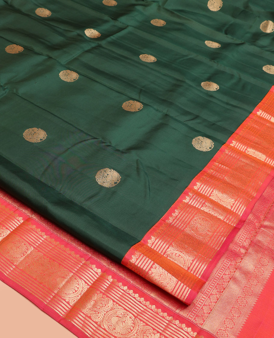 Green Vasundhara Silk Saree, Elevated with Mayil Zari Buttas All Over Its Body, Complemented by a Contrast  Border of Thilakam Mokku, Kathir, and Round Mayil Designs, Grand Jaal Pallu, and Paired with a Contrast Blouse