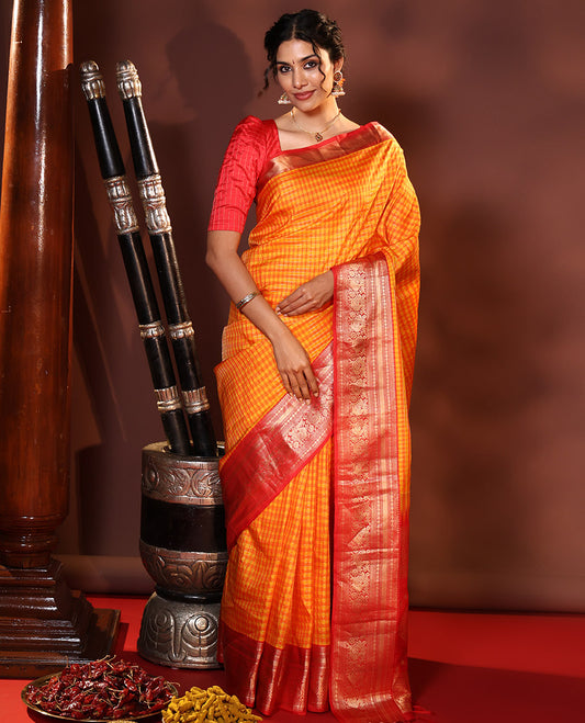 Orange Vasundhara Silk Saree Decked Up with Checks All Over Its Body, Complemented by Contrast Border of Rekku, Neli, Rudraksham, Kathir, and Mayil Designs, a Grand Pallu of Intricate Designs, and Paired with a Contrast Blouse