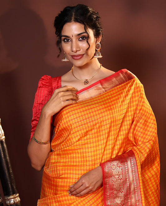 Orange Vasundhara Silk Saree Decked Up with Checks All Over Its Body, Complemented by Contrast Border of Rekku, Neli, Rudraksham, Kathir, and Mayil Designs, a Grand Pallu of Intricate Designs, and Paired with a Contrast Blouse