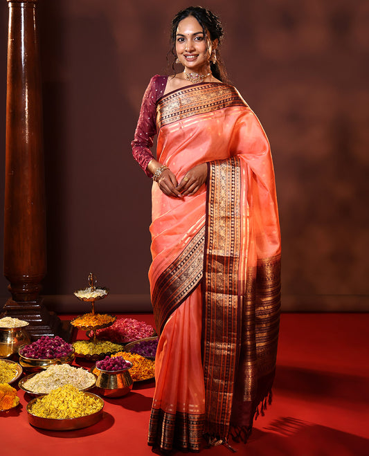 Peach Vasundhara Silk Saree Spotlighted with Zari Buttas All Over Its Body, Complemented by Contrast Border of Banaras, Neli, Floral, and Yaali Designs, Grandly Decked Up Pallu of Intricate Designs, and Paired with a Contrast Blouse