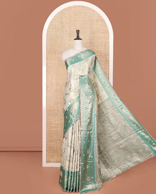 Beige Vastrakala Silk Saree Artfully Detailed with Floral Jacquard and Stone Work, Complemented by Contrast Traditional Zari and Stone Embroidered Scallop Border, Zari-Rich Jaal and Stone Work Pallu, and Paired with Contrast Stone Work Blouse