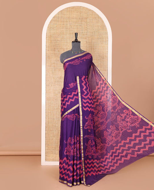 Violet wax batik-style zig-zag printed pure cotton saree, gold zari piping border, human figurines batik printed pallu, and a matching blouse
