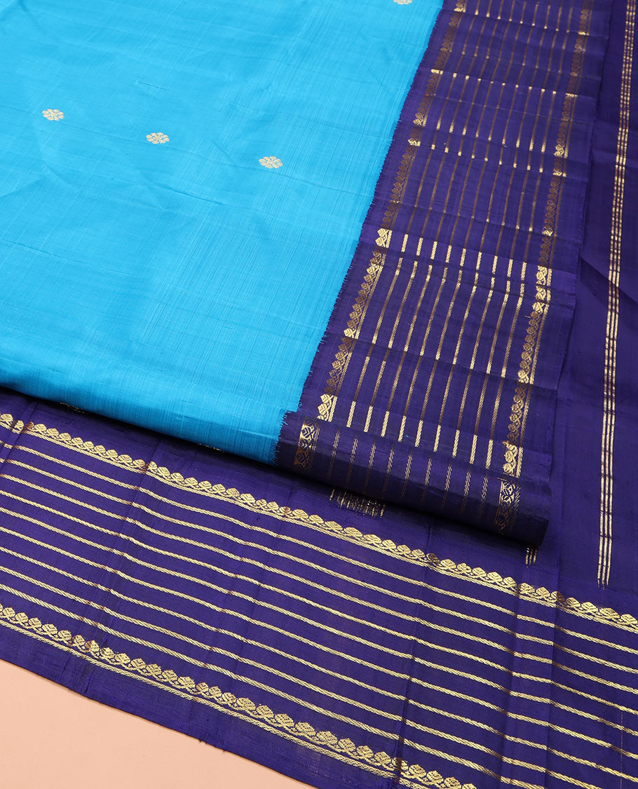 Blue Kanchipuram Silk Saree, Embellished with Zari Buttas, Complemented by Contrast One-Sided Korvai Border of Thilakam Mokku and Banaras Designs, Pallu Steeped with Floral Designs, and Comes Without a Blouse