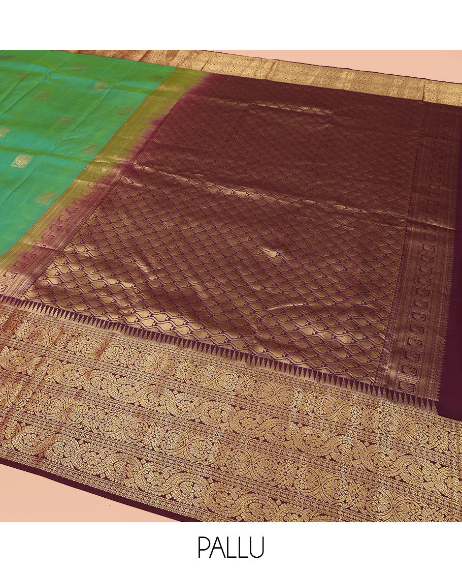 Sea Green Vasundhara Silk Saree, Accentuated with Zari Buttas All Over Its Body, Complemented by Contrast Border of Ara Bogudi, Banaras, Jada Nagam and Dhavana Kodi Designs, Pallu of Intricate Designs, and Paired with a Contrast Blouse