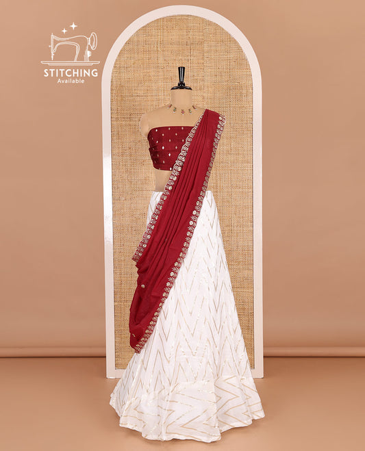 Cream-maroon half-saree, gold chevron striped nylon viscose crepe skirt, contrast diamond buttas blouse, and  a contrast scallop floral-theme embroidered dhavani