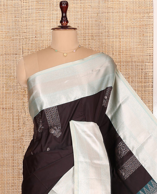 Dark Brown Budget Silk Saree, Majestically Detailed with Zari Buttas All Over Its Body, Complemented by a Contrast Border of Traditional Zari Designs, Beautifully Bedecked Pallu, and Paired with a Contrast Blouse
