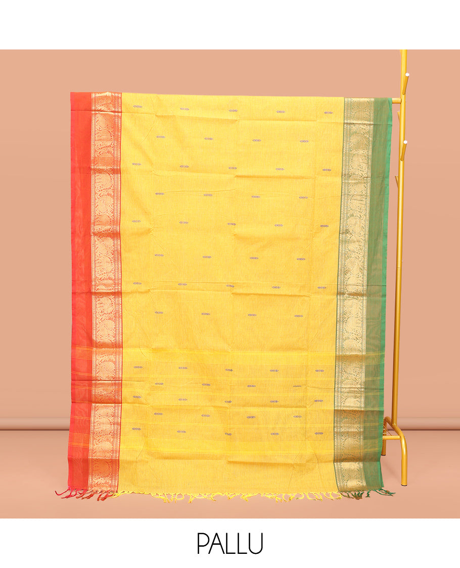 Yellow Chettinad Cotton Saree, Subtly Sparkled with Buttas All Over Its Body, Complemented by a Contrast Ganga-Jamuna Kal Eragina Border of Kodi Peacock and Elephant Designs, Pallu of Buttas and Stripes, and Paired with a Matching Blouse