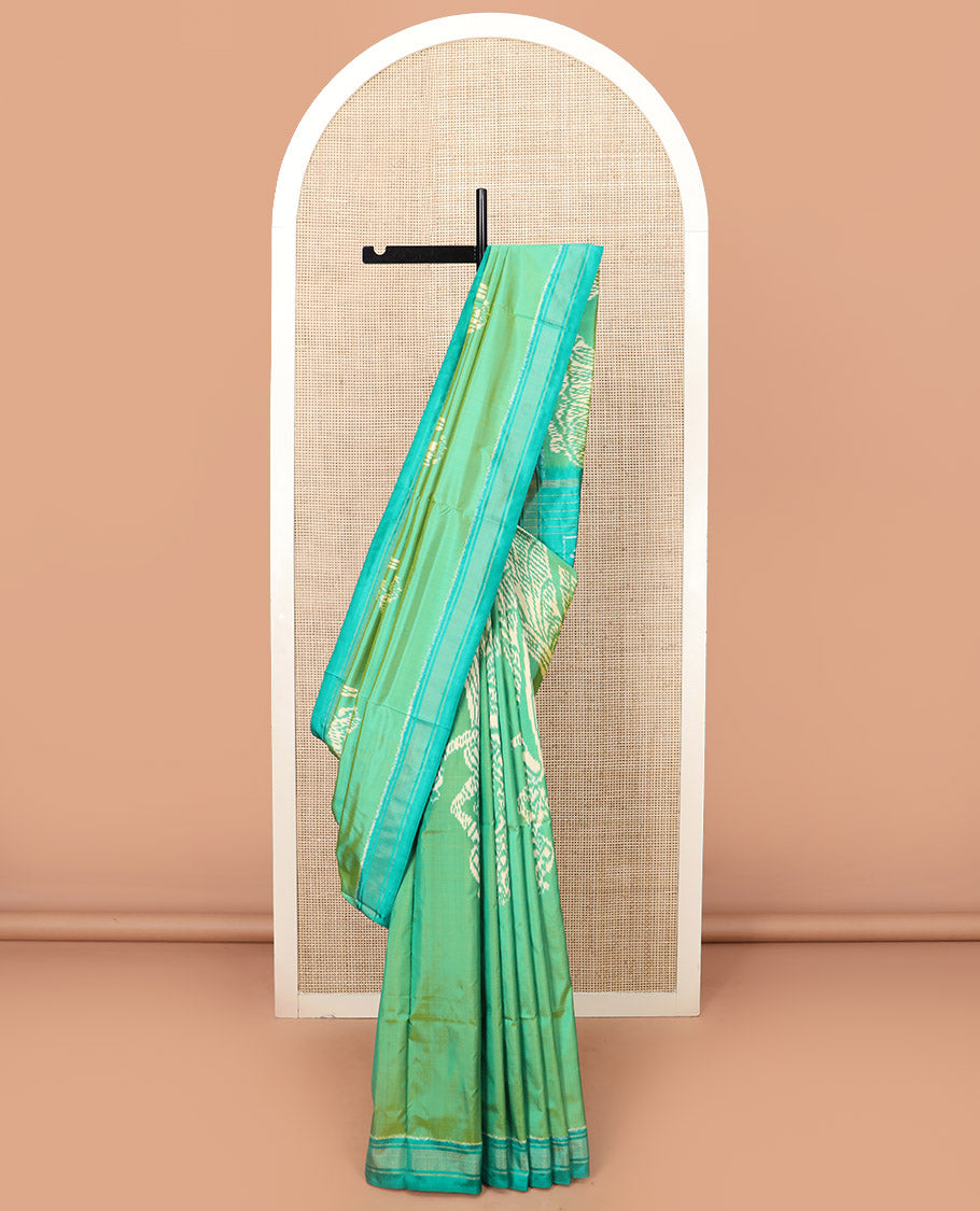 Green Ikkat Silk Saree Beautified with Human Figurines, Complemented by a Contrast Border, Hazily Woven Pallu of Geometric Patterns, and a Contrast Blouse