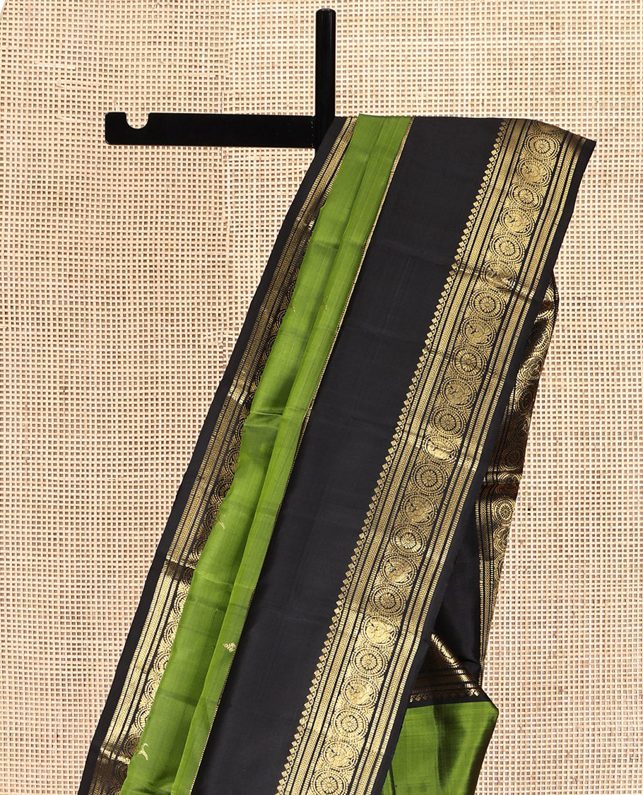 Green Kanchipuram Silk Saree, Ornamented with Zari Buttas All Over Its Body, Complemented by a Contrast Rettai Pettu Border of Salngai, Muthu, Kathir, Chakram, and Round Mayil Designs, Grand Pallu, and Paired with a Contrast Blouse