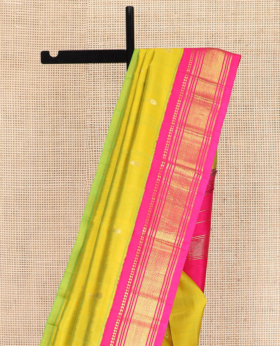 Green Kanchipuram Silk Saree Sparsely Sparkled with Zari Buttas All Over Its Body, Complemented by Contrast One-Sided Korvai Border of Paneer Sombu, Banaras, Muthu, and Mayil Kann Designs, Pallu of Zari Designs, and Comes Without a Blouse
