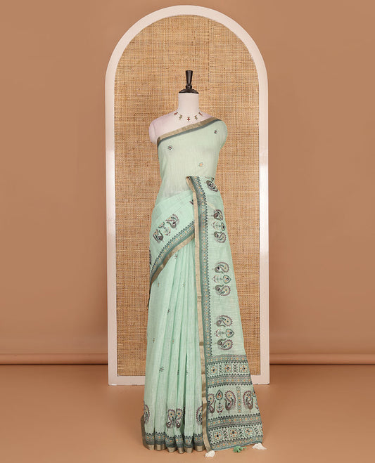 Green buttas with mirror work linen saree, zari border with peacock motifs print, printed mirror work pallu, and matching blouse