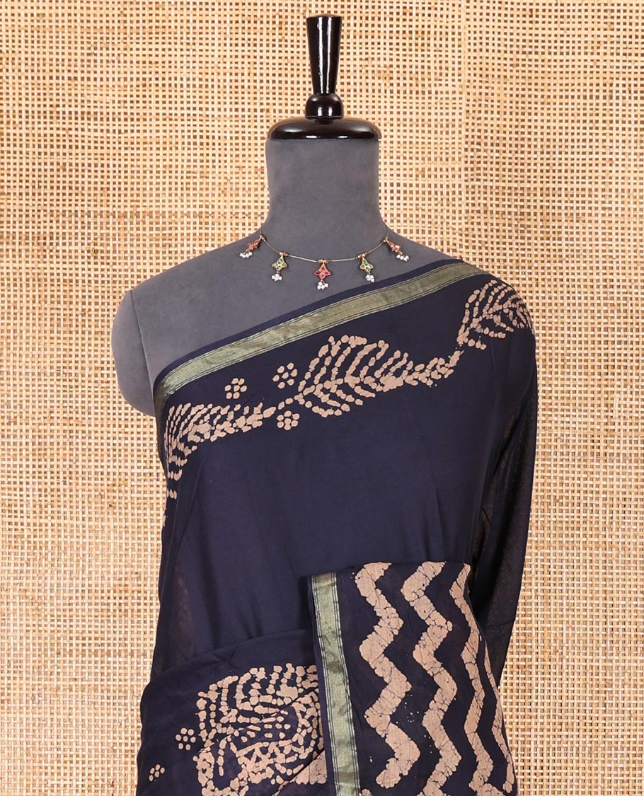 Navy blue wax batik-style zig-zag printed pure cotton saree, gold zari piping border, human figurines batik printed pallu, and a matching blouse