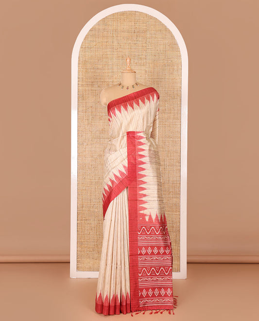 Chikku-red plain Khicha katan silk saree, contrast red temple border, ikkat printed pallu with tassels, and a contrast blouse