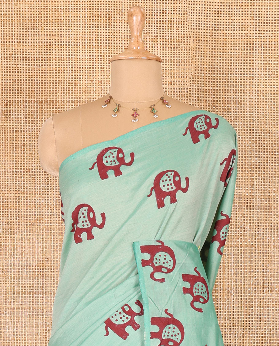 Sea green plain South cotton saree with elephant motifs block printed border, a matching blouse and a contrast floral motifs printed blouse