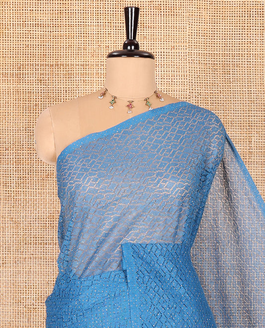 Borderless blue sparkling glitter russel net saree with self-pallu, and a contrast floral printed and zig-zag patterned blouse