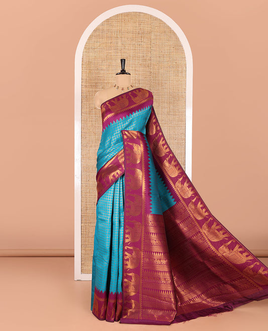 Peacock green checked design litchi saree, contrast temple elephant motifs border, geometric patterned pallu, and a contrast jacquard blouse