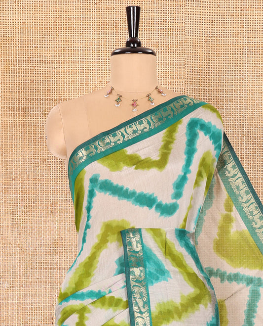 Olive Muslin Cotton Saree Decked Up with Zig-Zag Shibori Patterns Prints, Complemented by a Contrast Border of Deer Motifs in Zari, Pallu Decked Up with Scenery Print, and Paired with a Contrast Polka Dots Printed Blouse