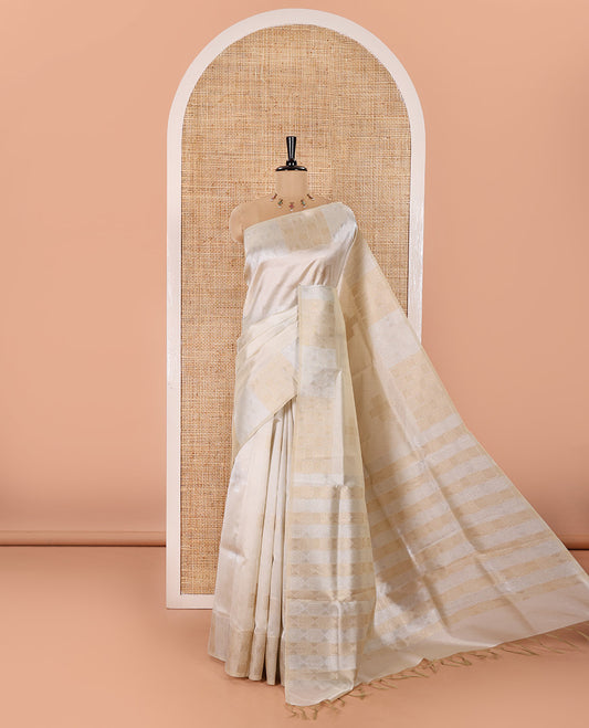 Cream Semi Tussar Saree Elevated with Zari Plus-Shaped Buttas, Gleaming Border of Intricate Zari Checks, Pallu Richly Woven with Jaal Designs, and Paired with a Matching Blouse