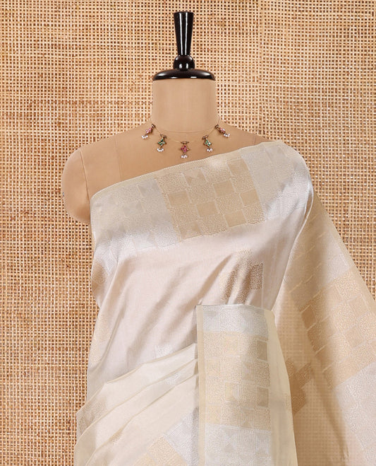 Cream Semi Tussar Saree Elevated with Zari Plus-Shaped Buttas, Gleaming Border of Intricate Zari Checks, Pallu Richly Woven with Jaal Designs, and Paired with a Matching Blouse