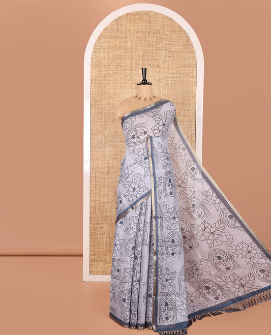 Light Grey Linen Saree Creatively Printed with Girl Face and Floral Motifs All Over Its Body, Subtly Sparkled with Piping Zari Border, Pallu Mirrors the Same Body Print, and Paired with a Contrast Blouse