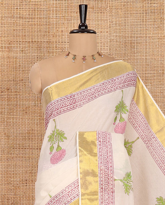 Cream Kerala Cotton Saree, Adorned with Floral Buttas All Over Its Body, Highlighted by Golden Zari Border, Pallu Depicts the Same Floral Print, and Paired with a Matching Floral Printed Blouse