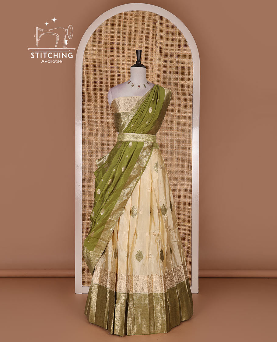Cream taffeta silk half saree, meena buttas skirt, contrast mehendi green  traditional zari border, matching blouse, and zari woven dhavani