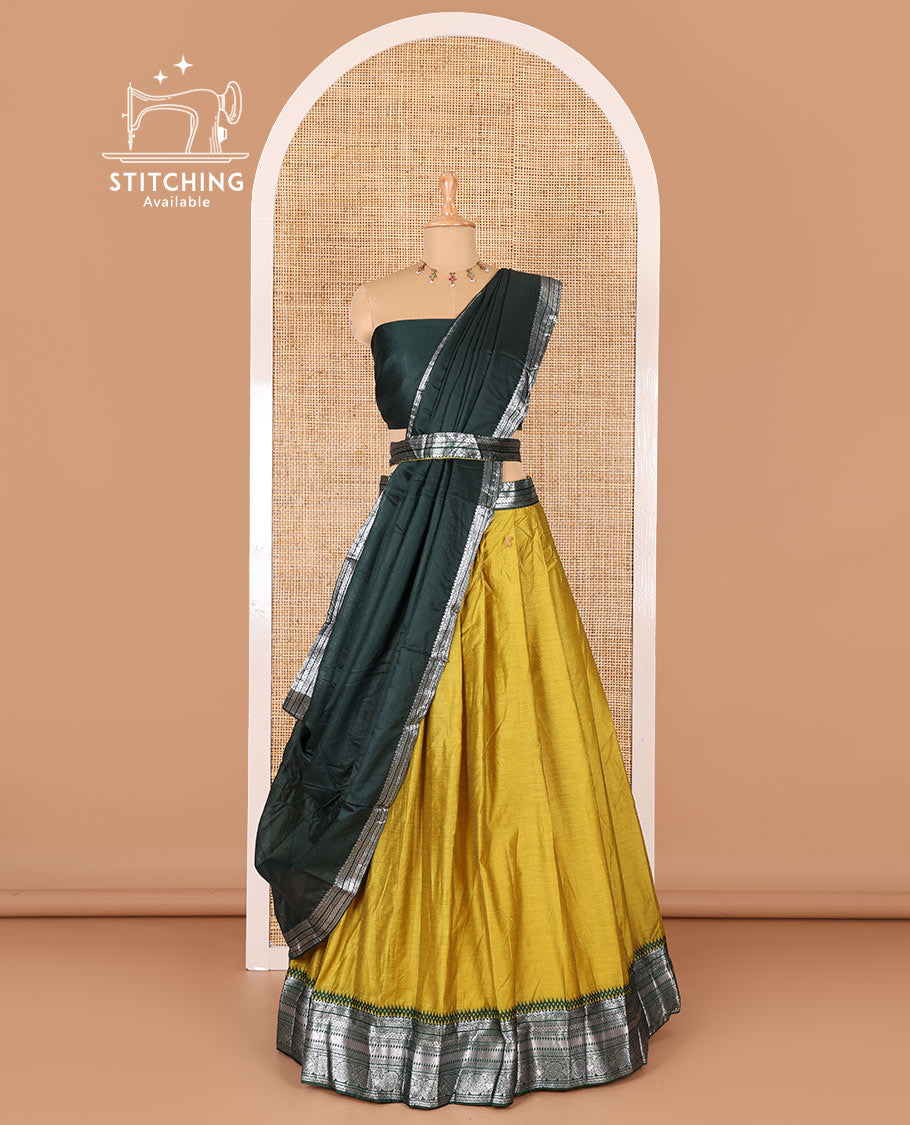 Manga yellow taffeta silk half-saree, plain with a contrast traditional design bordered skirt, contrast blouse, and traditional zari bordered blouse