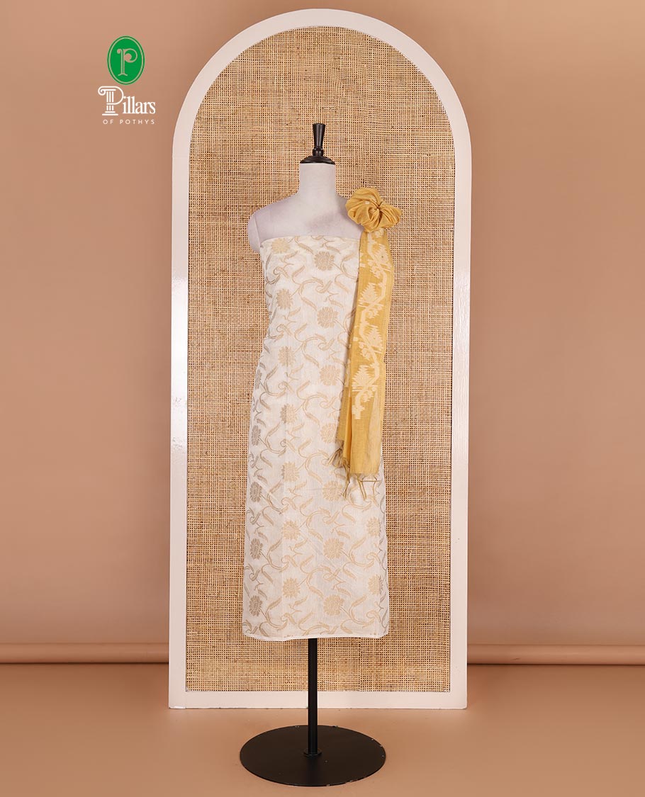 Cream with yellow semi-chanderi material churidar set, floral jaal jacquard top, contrast taffeta silk bottom, and jamdani style dupatta
