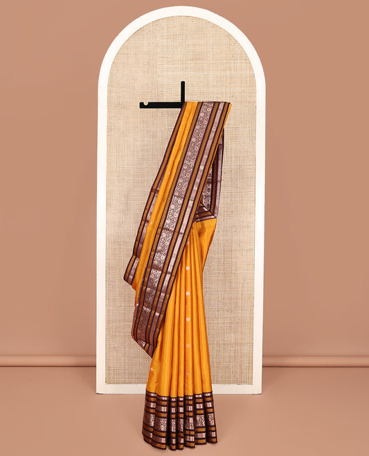 Yellow Vasundhara Silk Saree, Richly Detailed with Zari Buttas All Over Its Body, Complemented by a Contrast Border of Thilakam, Neli, Laddu Kamalam, and Kodi Visiry Designs, Pallu of Butta Enclosed Checks, and Paired with a Contrast Blouse