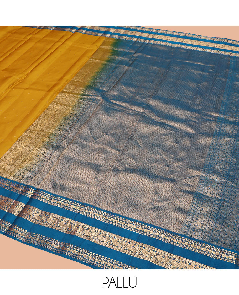 Yellow Vasundhara Silk Saree, Embellished with Zari Buttas All Over Its Body, Complemented by a Contrast Border of Rekku, Banaras, Rudraksham, Neli, and Mayil Designs, Grand Pallu of Geometric Patterns, and Paired with a Contrast Blouse