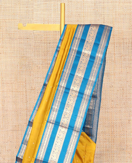 Yellow Vasundhara Silk Saree, Embellished with Zari Buttas All Over Its Body, Complemented by a Contrast Border of Rekku, Banaras, Rudraksham, Neli, and Mayil Designs, Grand Pallu of Geometric Patterns, and Paired with a Contrast Blouse