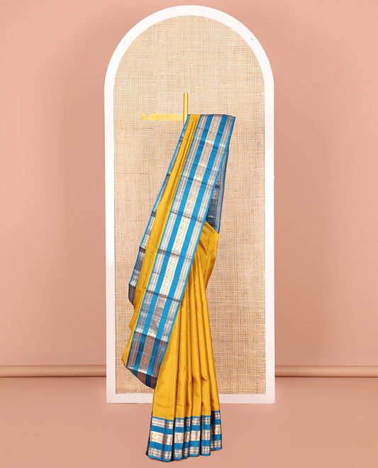 Yellow Vasundhara Silk Saree, Embellished with Zari Buttas All Over Its Body, Complemented by a Contrast Border of Rekku, Banaras, Rudraksham, Neli, and Mayil Designs, Grand Pallu of Geometric Patterns, and Paired with a Contrast Blouse