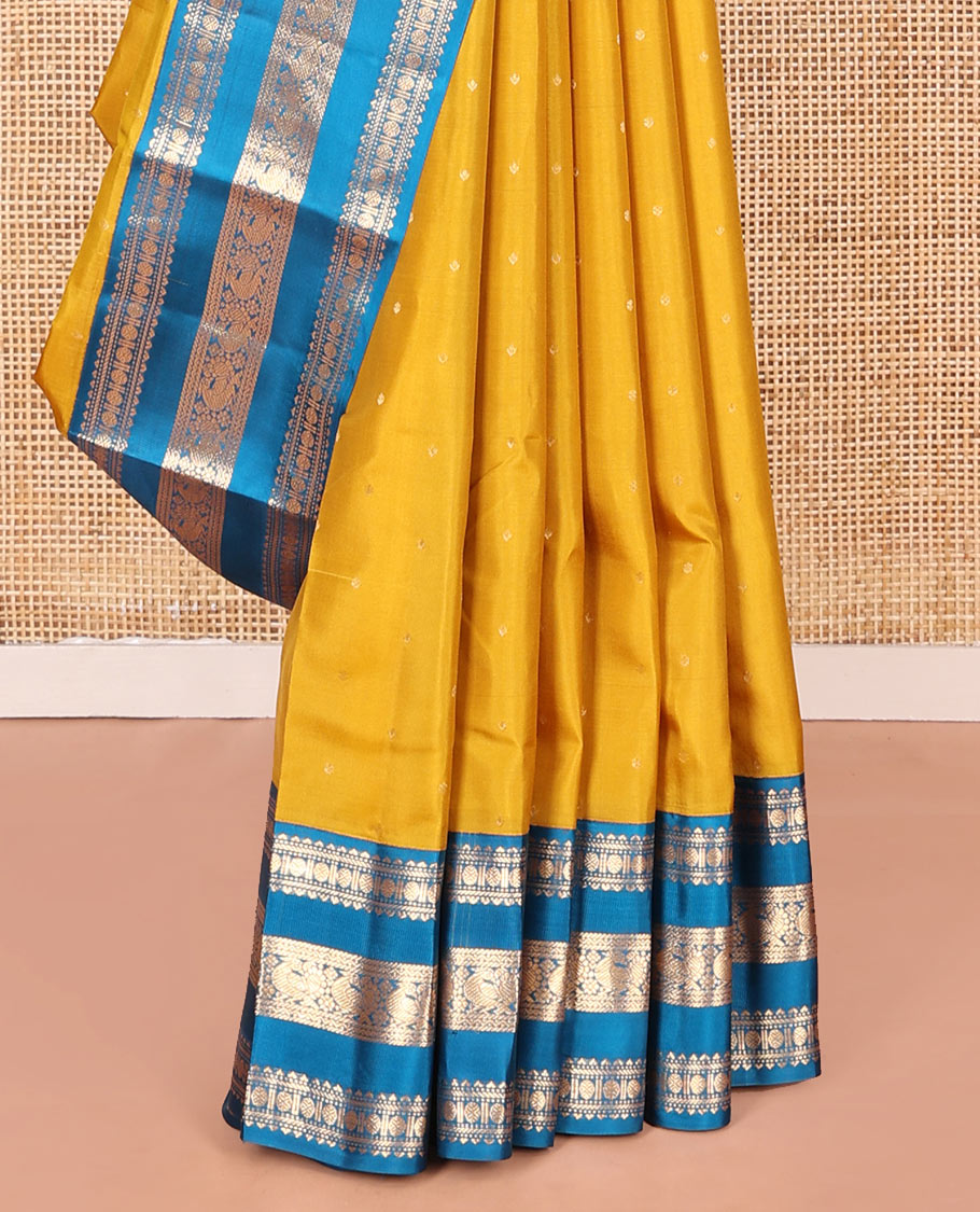 Yellow Vasundhara Silk Saree, Embellished with Zari Buttas All Over Its Body, Complemented by a Contrast Border of Rekku, Banaras, Rudraksham, Neli, and Mayil Designs, Grand Pallu of Geometric Patterns, and Paired with a Contrast Blouse