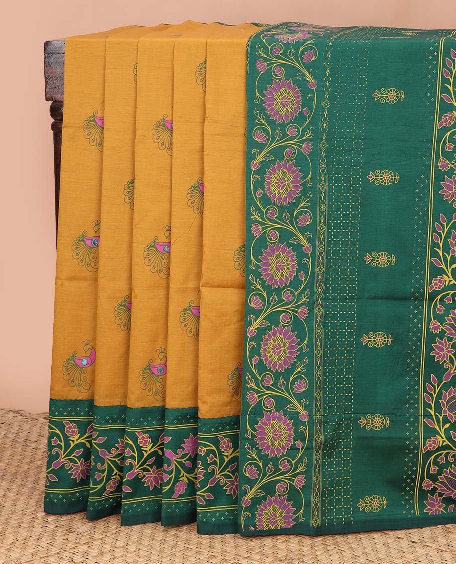 Mustard peacock motifs printed poly cotton saree, contrast floral creeper printed border, and pallu of floral creeper design