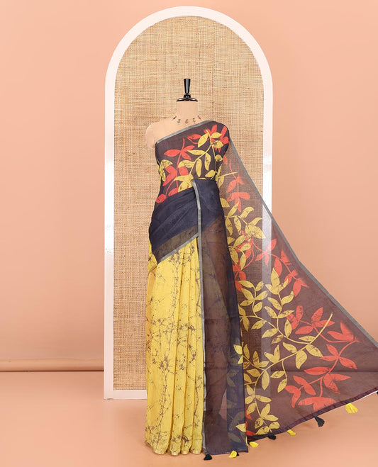 Yellow and black batik print and leaf vine printed linen saree, zari piping border, printed pallu, and a contrast batik printed blouse