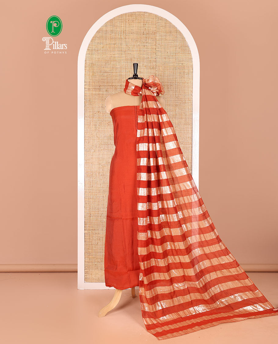 Rust material chudidar set, plain with pom-pom tasseled mul chanderi top, a matching bottom, and organza dupatta of stripes